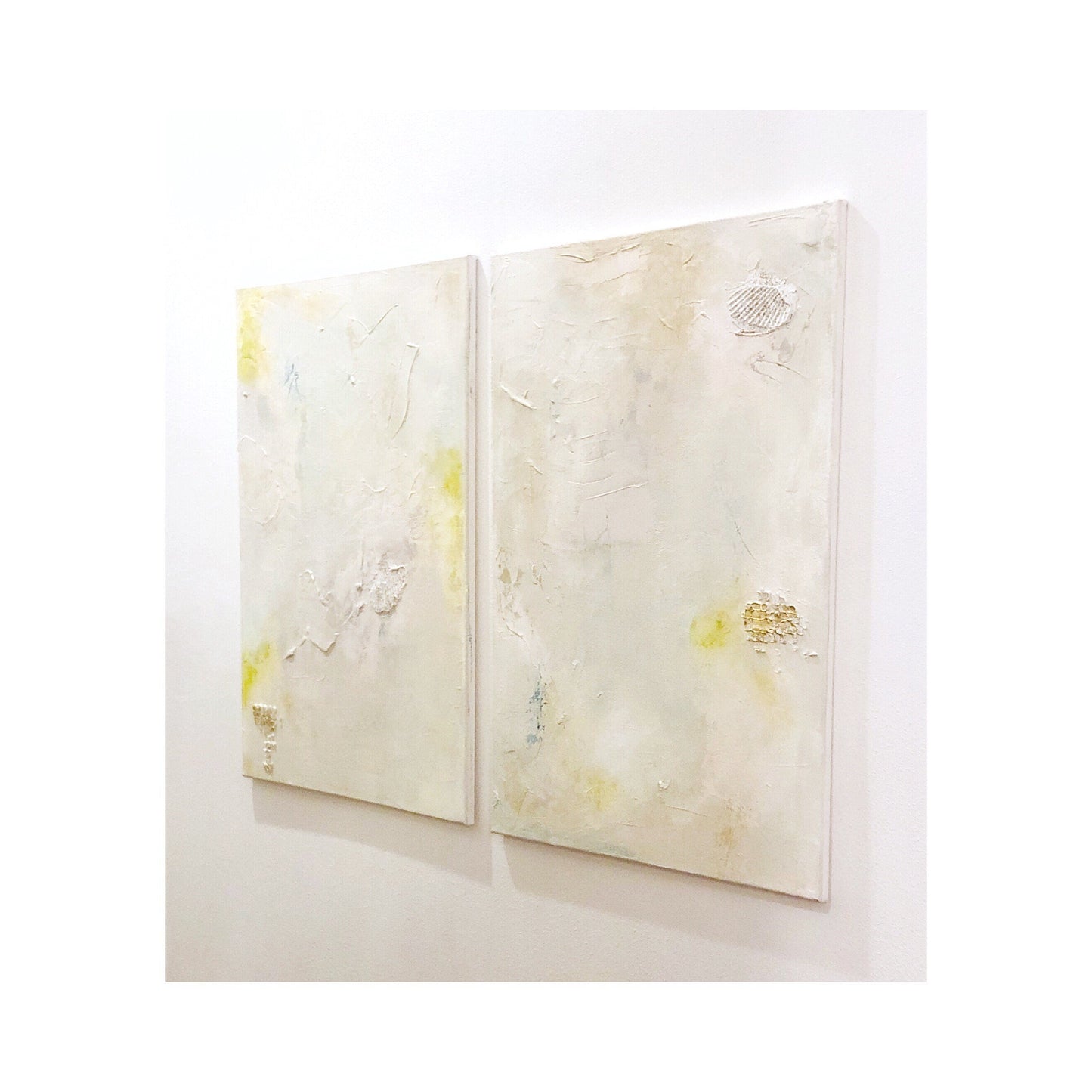 Set of 2 custom large abstract canvas paintings in neutral tones with subtle yellow accents and textured mixed media design.