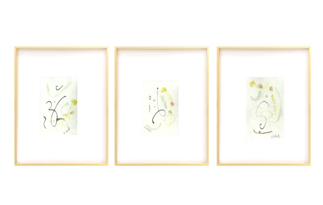 Set of 3 framed abstract watercolor paintings in pastel pink, green, and yellow with white mats and gold frames