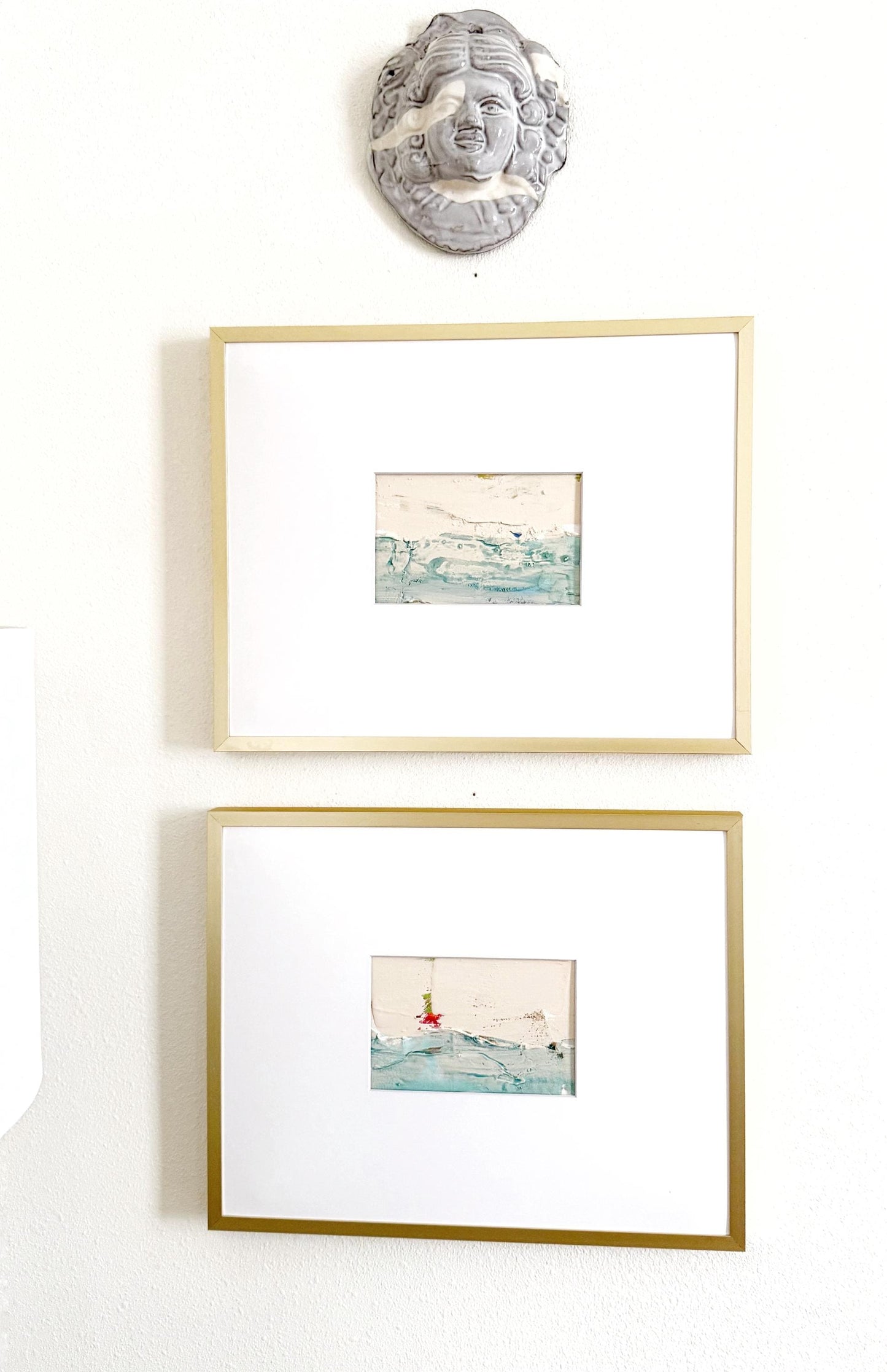 Original abstract mixed media landscape paintings set of 2 in gold frames with white mats, featuring muted blue and green hues and gold ink accents.